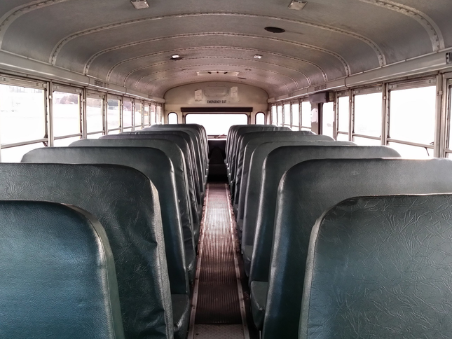 The interior of a school bus with a view of the back door